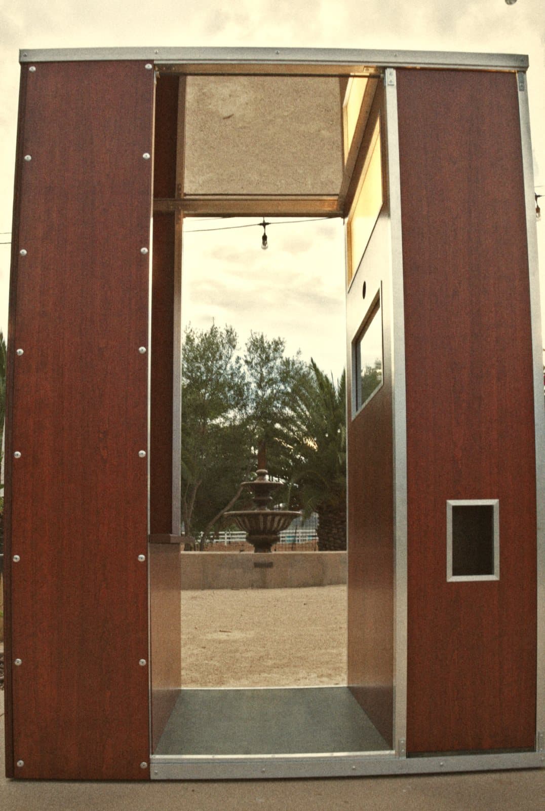 Front view through the open booth toward a courtyard fountain